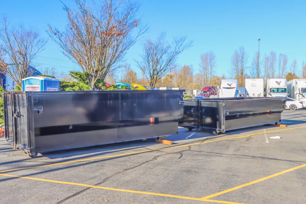 Professional dumpster rental service with roll-off container on residential driveway in Herrin